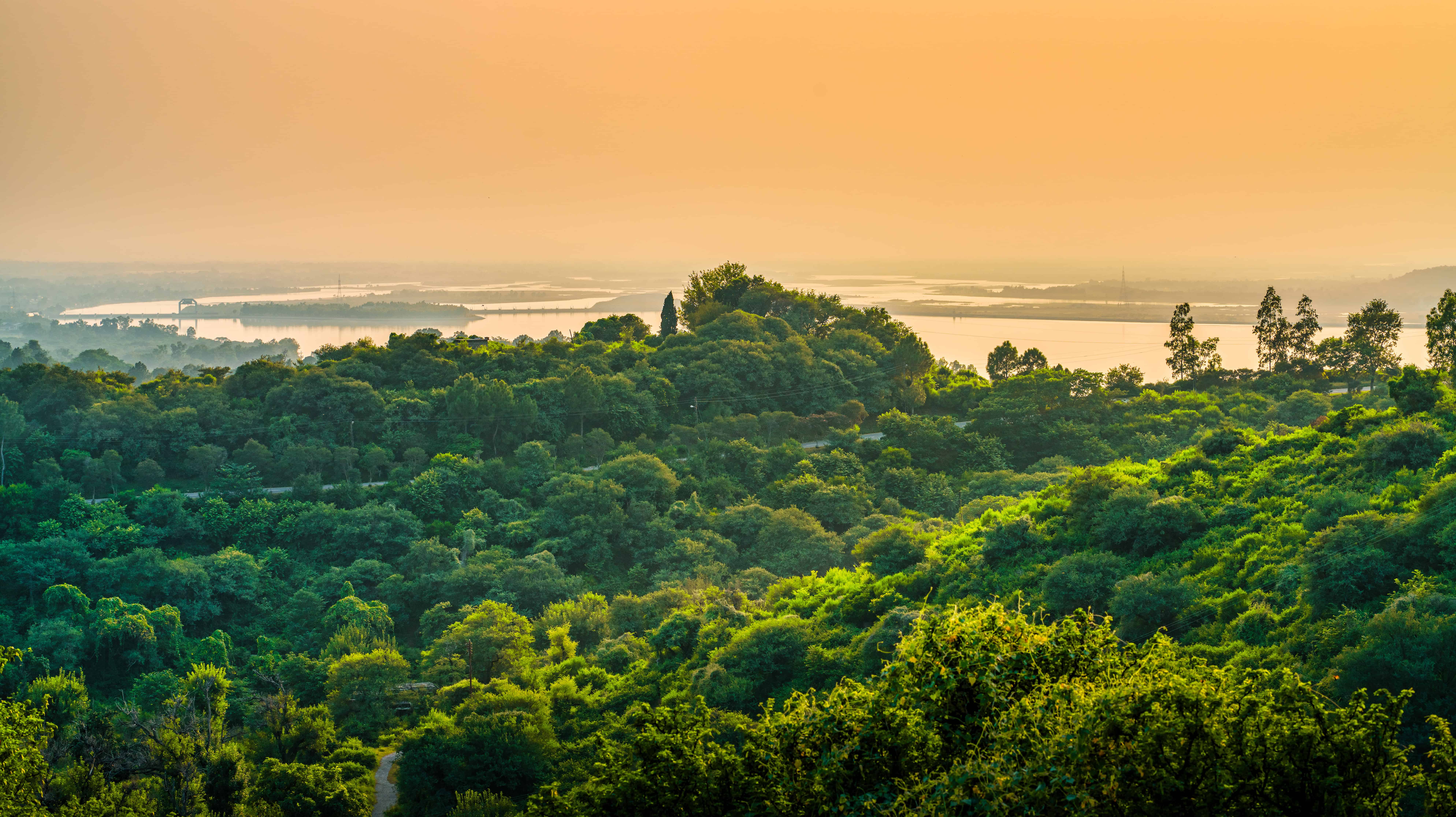 landscape-hills-covered-greenery-surrounded-by-sea-cloudy-sky-sunset